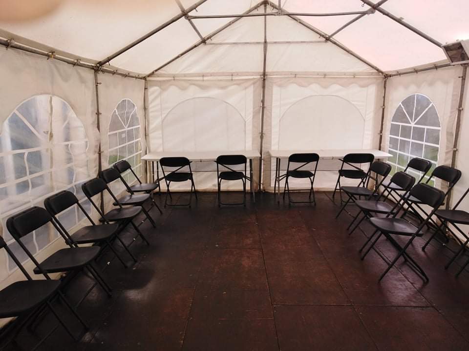 Image of marquee for hire with tables, chairs, flooring, lights and heat